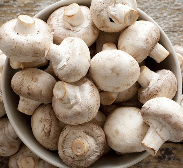 raw mushrooms in a white bowl